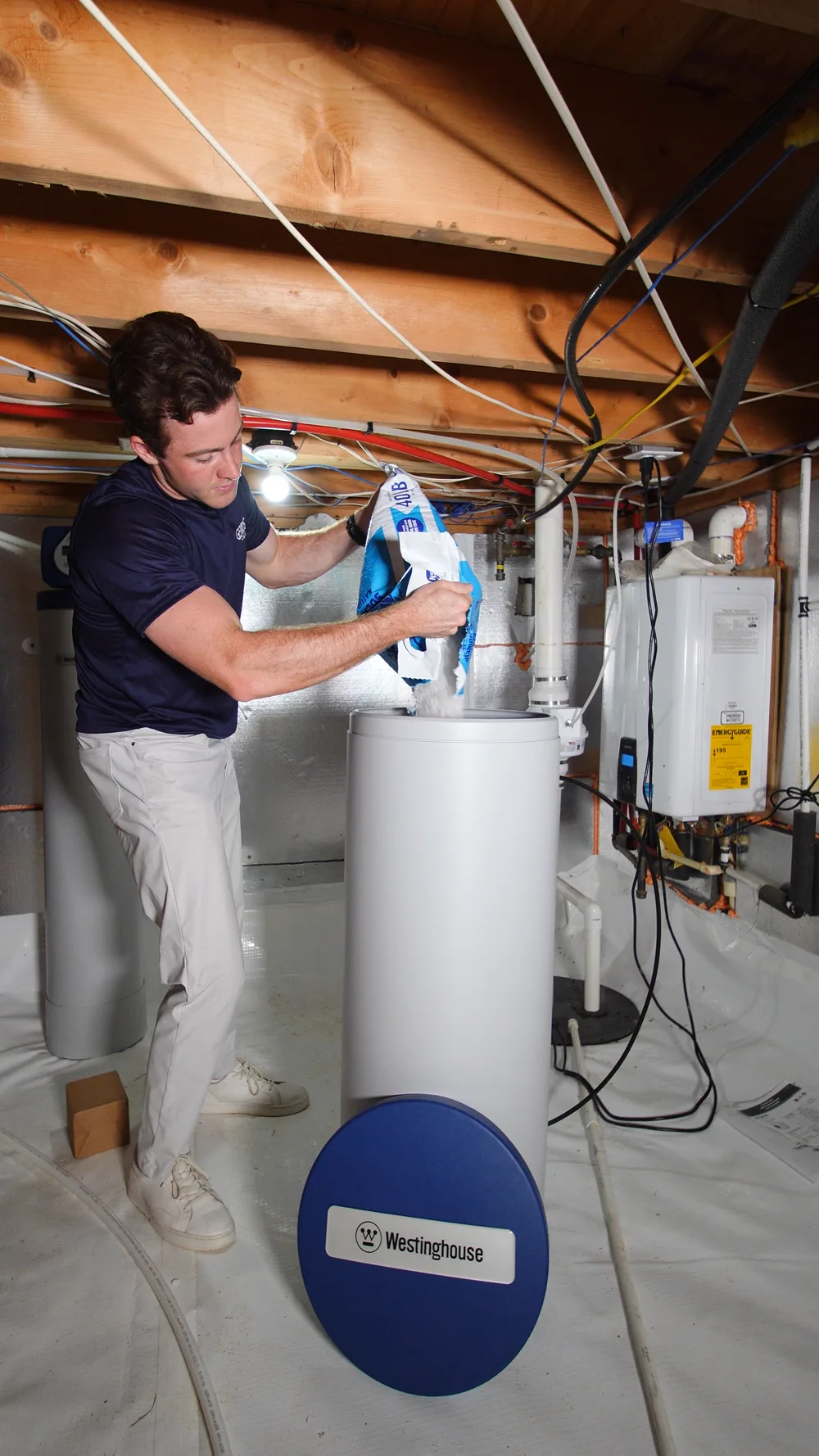 Genius Water Co. technician installing a whole-home water softener in a Triangle garage