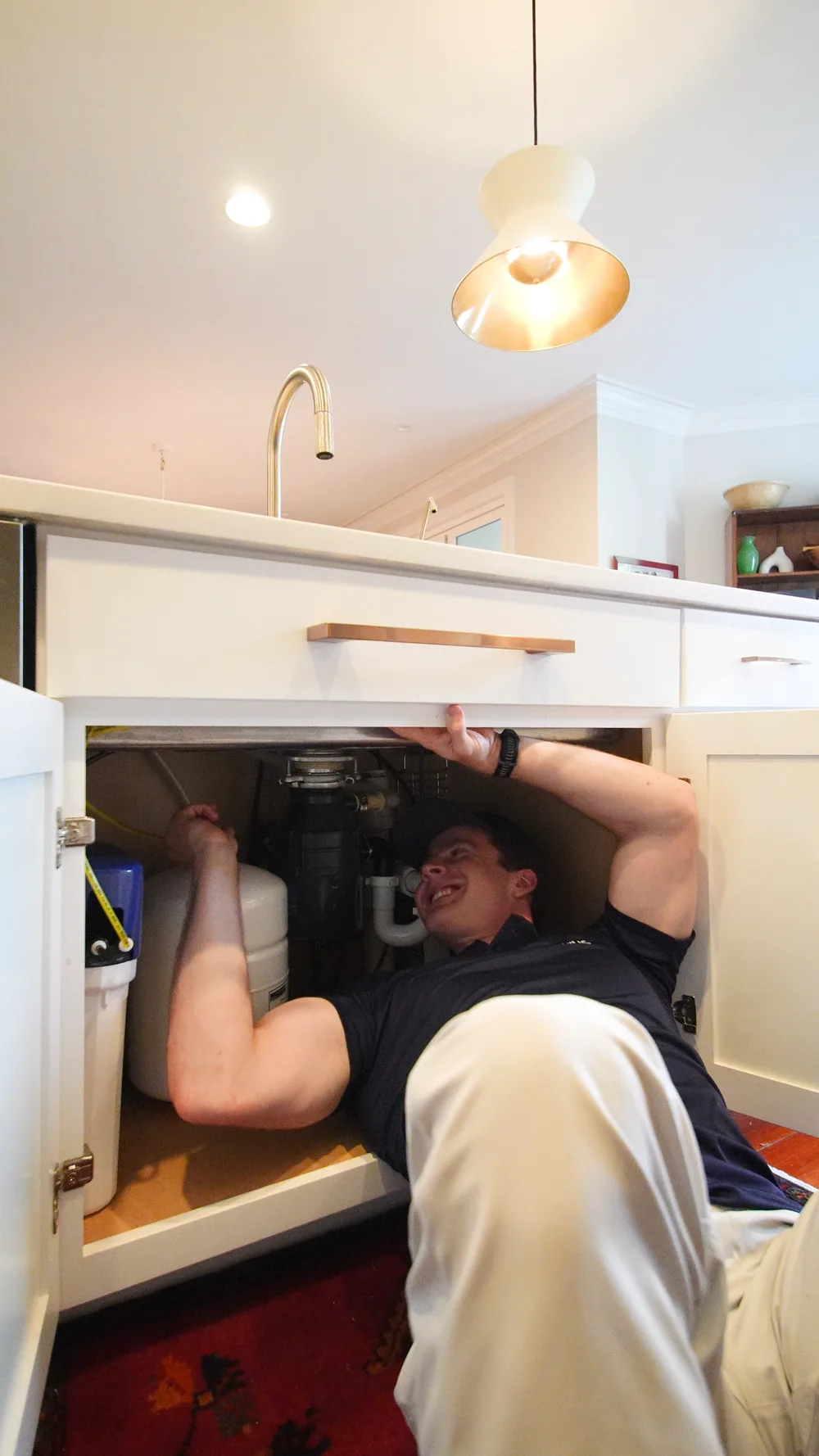 Genius Water Co. technician installing a reverse osmosis system under a kitchen sink