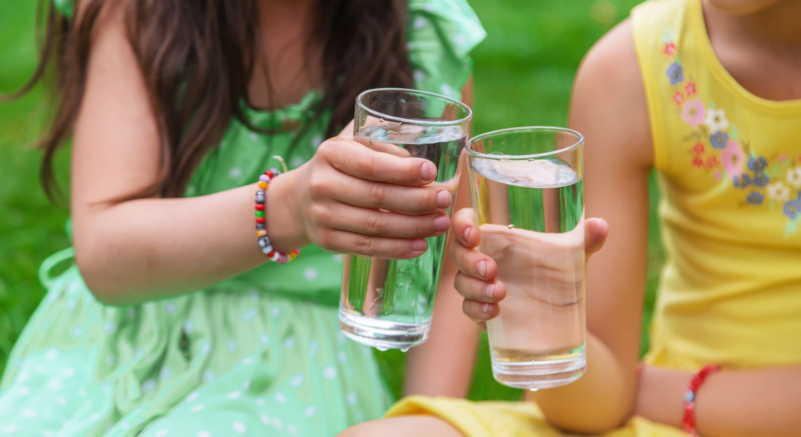 Kids toasting glasses of clean filtered water outside