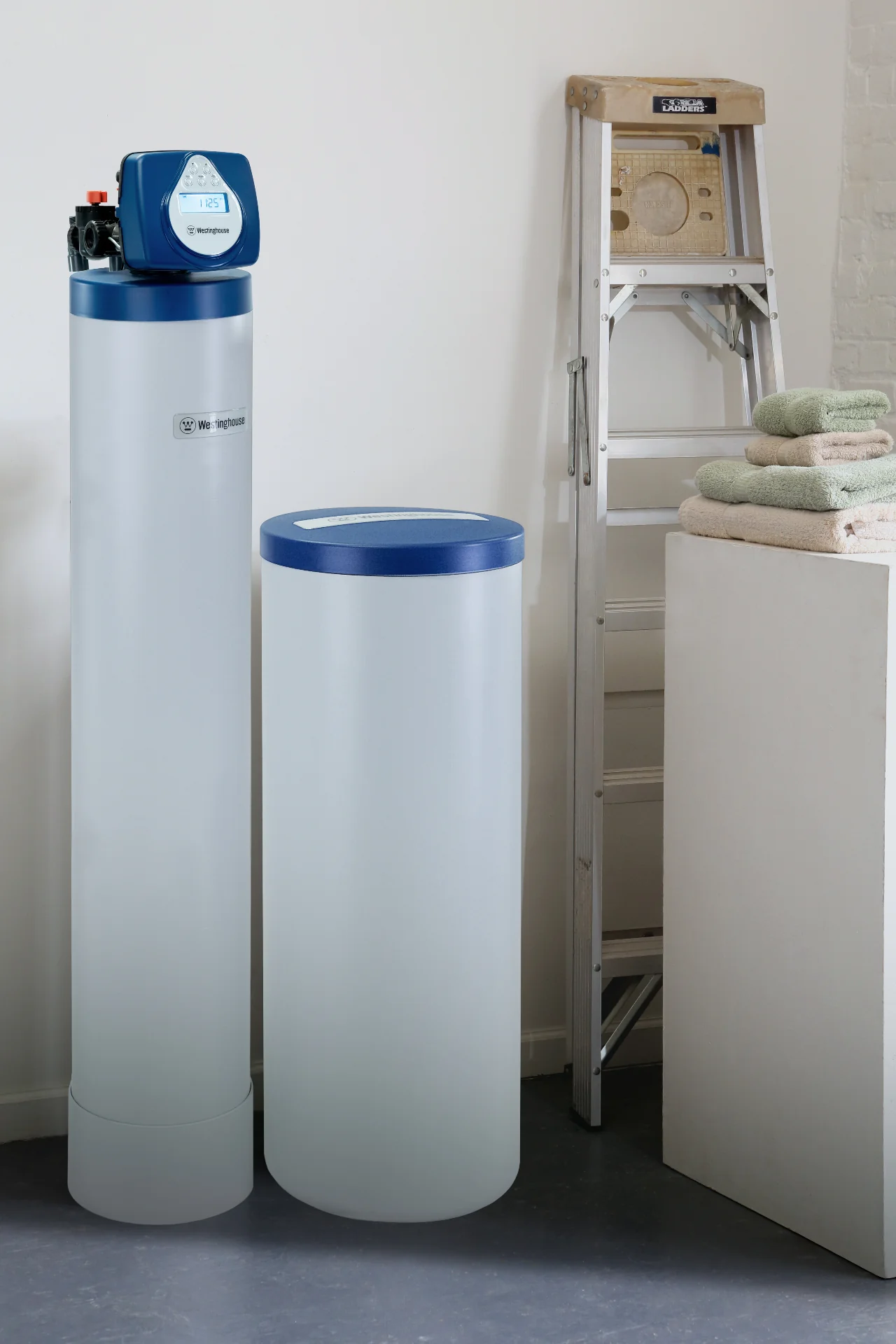 Whole-home water softener installed in Raleigh, NC home — mineral tank and brine tank in laundry room